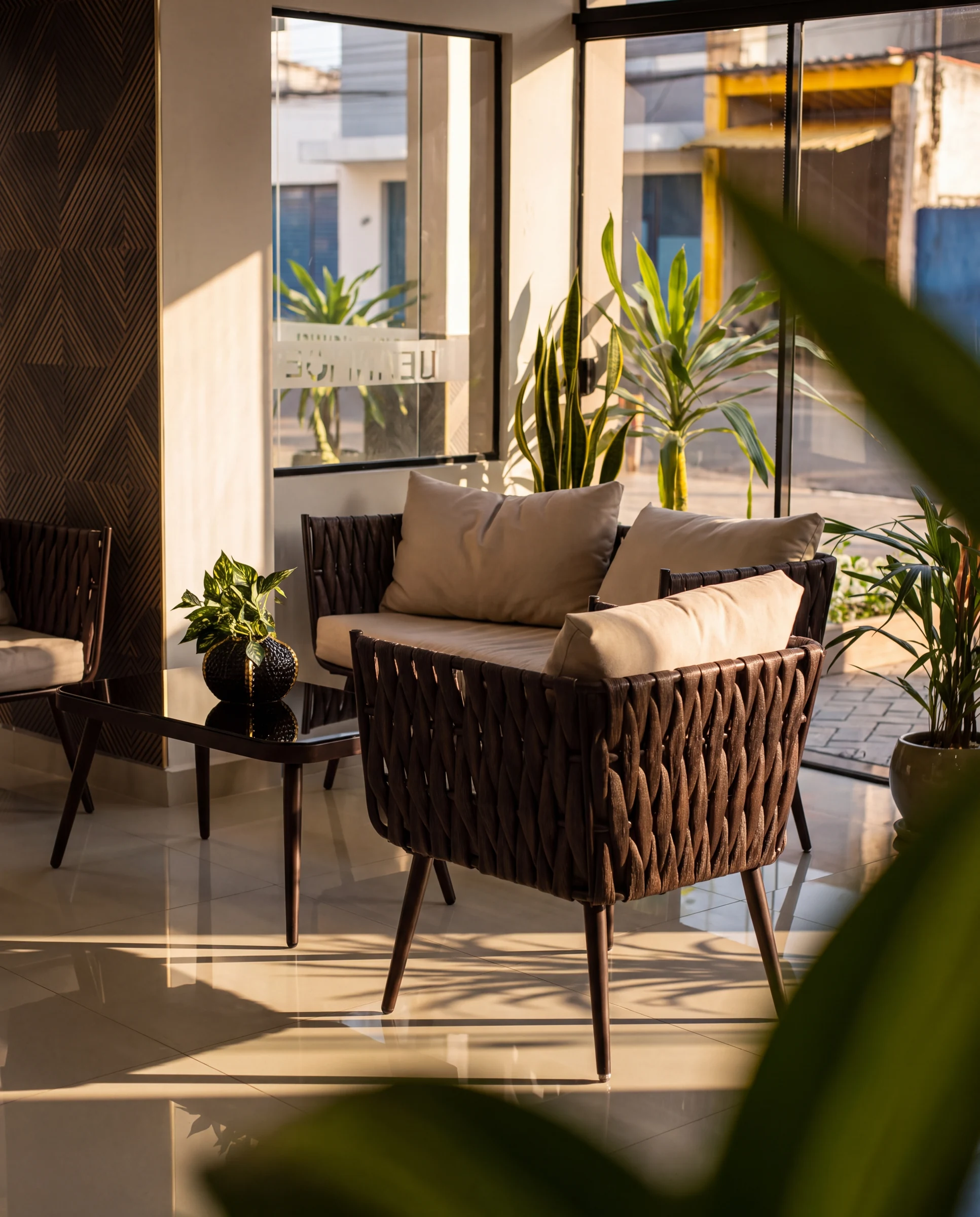 Rincón del hotel con sillones, plantas y ventanales